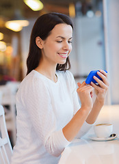 Image showing smiling woman with smartphone and coffee at cafe