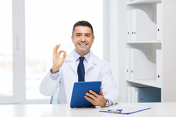 Image showing smiling doctor with tablet pc showing ok hand sign