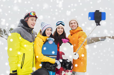 Image showing happy friends with snowboards and smartphone