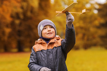 Image showing happy little boy playing with toy plane outdoors