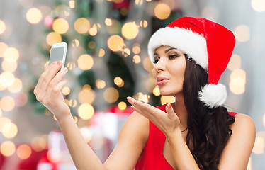 Image showing woman in santa hat taking selfie by smartphone