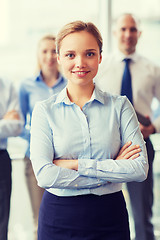 Image showing smiling businesswoman with colleagues in office