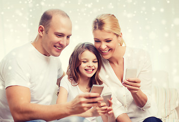 Image showing happy family with smartphones at home