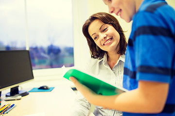 Image showing school boy with notebook and teacher in classroom