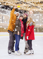 Image showing happy friends taking selfie on skating rink