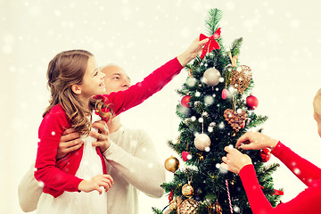 Image showing smiling family decorating christmas tree at home