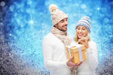 Image showing smiling couple in winter clothes with gift box