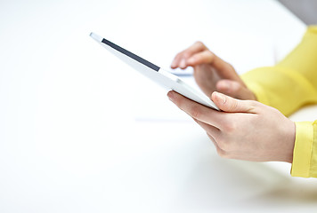 Image showing close up of female hands with tablet pc at table