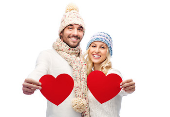 Image showing smiling couple in winter clothes with red hearts