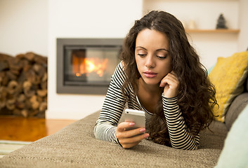 Image showing Woman with her cellphone at home