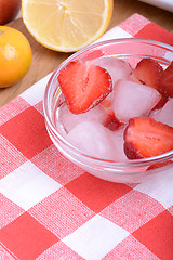 Image showing A slice of red strawberry on glass plate with lemon and mandarin in party theme background