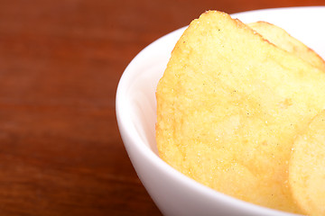 Image showing Crispy potato chips close up on white plate 