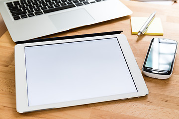 Image showing Working table with cellphone and digital tablet showing a blank 