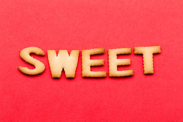 Image showing Word sweet biscuit over the red background