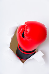 Image showing Boxing glove through a hole in paper