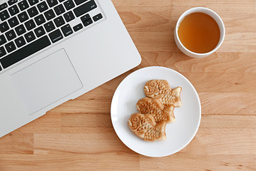 Image showing Fish shapes waffle with tea and laptop