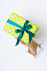 Image showing Hand breaking white paper showing gift box