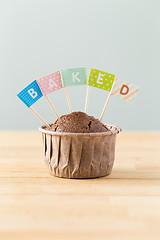 Image showing Chocolate muffins with small flag of a word baked