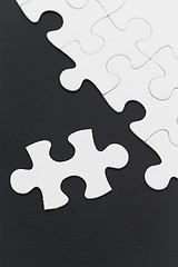 Image showing Plain white jigsaw puzzle on black background