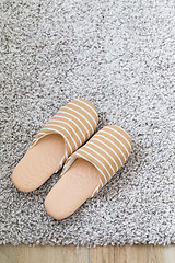 Image showing Brown slippers on grey carpet