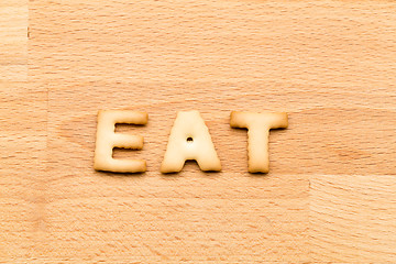 Image showing Word eat cookie over the wooden background