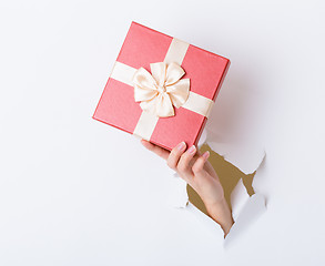 Image showing Hand hold with gift box through the white paper