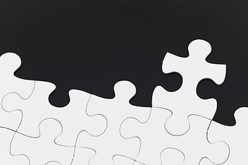 Image showing White puzzle over black background