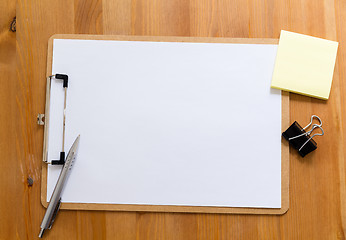 Image showing Office desk with clipboard showing a blank paper for advertising