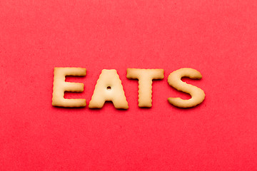 Image showing Word eats biscuit over the red background