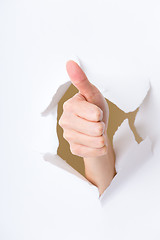 Image showing Thumb up hand gesture break through the paper wall