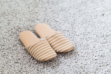 Image showing Pair of white slippers on a carpet