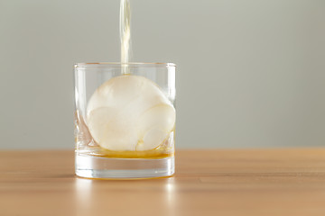 Image showing Whiskey or brandy being poured into a glass