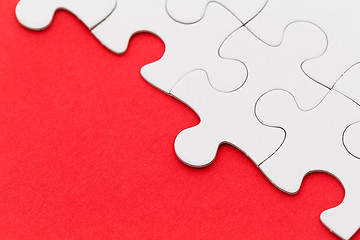 Image showing Jigsaw puzzle on red paper