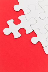 Image showing Plain white jigsaw puzzle on Red background
