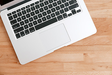 Image showing Laptop computer on a wooden desk. Top view