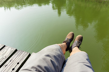 Image showing Man legs sitting on wooden path