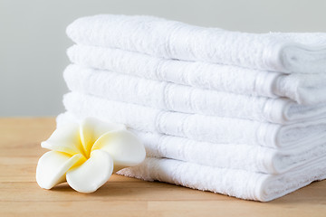 Image showing Plumeria flower with stack of white towel