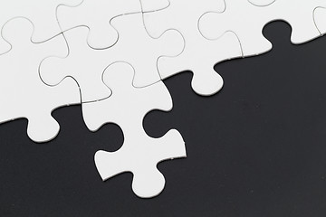 Image showing Plain white jigsaw puzzle on Black background