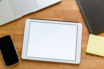 Image showing Business working desk with tablet showing a blank screen for adv