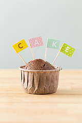 Image showing Chocolate muffins with small flag of a word cake