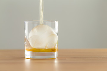 Image showing Pouring whiskey drink into glass
