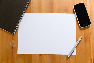 Image showing Empty White paper on desk with cellphone for adding information