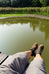 Image showing Male legs over the river