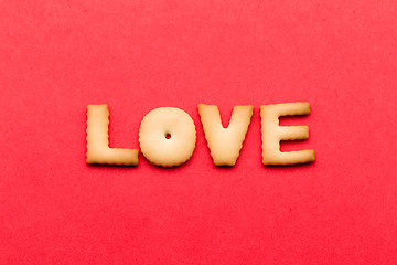 Image showing Word LOVE biscuit over the red background