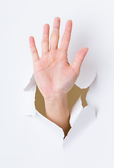 Image showing Hand palm breaking through paper wall