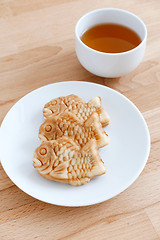 Image showing Taiyaki fish cake with cup of tea