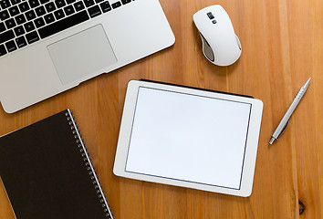 Image showing Office table with digital tablet showing a blank screen for adve