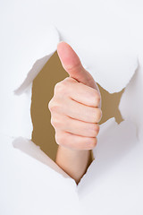 Image showing Thumb up hand gesture break through the paper wall