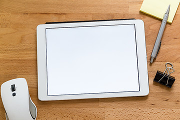 Image showing Modern working desk with digital tablet presenting a blank scree