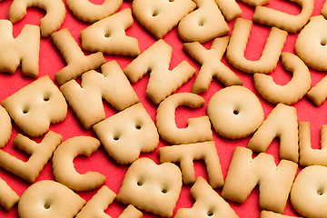 Image showing Assorted text biscuit over red background